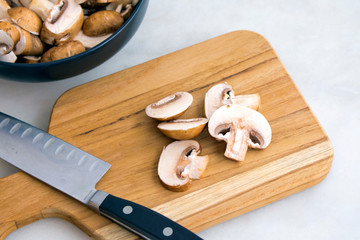 Slicing Cremini Mushrooms on a Wood Cutting Board