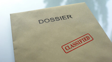 Dossier classified, seal stamped on folder with important documents, close up