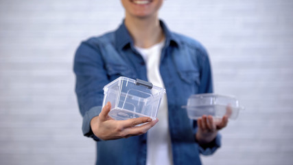 Female choosing bioplastic food container instead non-disposable box, pollution