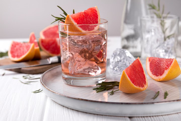Grapefruit cocktail with rosemary on white wooden table