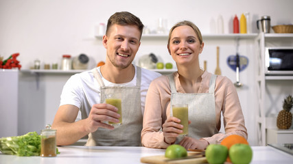 Joyful couple holding spirulina smoothie, recommending healthy drink, vitamins