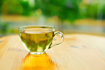 Green tea in a cup on wooden table