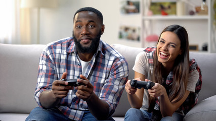 Laughing mixed-race family having fun, playing video game at home, leisure time