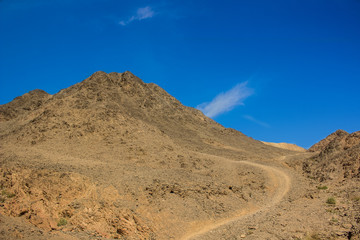 Asian picturesque scenery landscape national park photography of desert rocky mountains wilderness wasteland environment with lonely trail for hiking on vivid blue sky background 