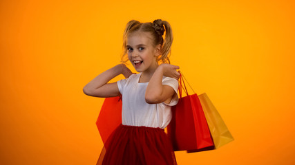 Cute little princess holding shopping bags, black friday sales, shopaholic