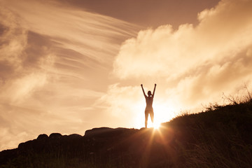 Silhouette of woman on top of the mountain. victory winning concept. 
