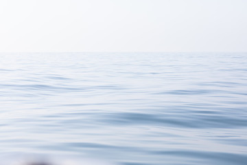 Naklejka premium Tranquil and serene ocean surface. Calm and relaxed mirror-like blue sea background.