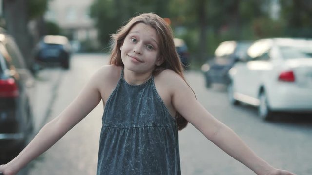 Nice surprised girl standing in road and shrugging. Close-up footage of pretty teenager in romantic sundress. Autos. Summertime. Outdoors, beautiful, lovely, nice, cute, pretty