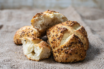 Fresh hot homemade bread with seeds isolated on sackcloth background. Healthy and tasty food concept.