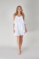 Pretty woman beautiful face bright makeup long blond hair fashion model wear trend clothes for date party summer walk travel cruise collection organic silk cotton dress accessory jewelry white studio.