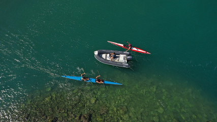 Aerial drone photo of young men competing with sport canoe in tropical lake with calm waters