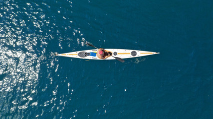 Aerial drone photo of fit man practising sport canoe in calm water sea