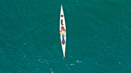Aerial drone photo of fit man practising sport canoe in calm water sea