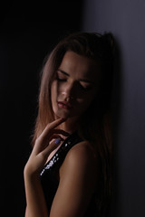 Beautiful portrait of a girl in a shiny vest on a black background photo for text