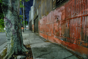 Night shot of a  banged up red metal fence 