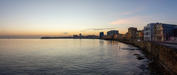 Fototapeta premium Beautiful panoramic view of the Old Havana City, Capital of Cuba, by the Ocean Coast during a vibrant sunny sunrise.