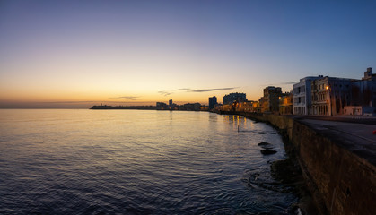Obraz premium Beautiful panoramic view of the Old Havana City, Capital of Cuba, by the Ocean Coast during a vibrant sunny sunrise.