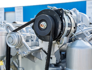 Belt drive with rollers tensioner close-up. Fragment of a modern car engine