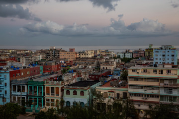 Fototapeta premium Aerial view of the residential homes in Havana City, Capital of Cuba, during a colorful cloudy sunrise.