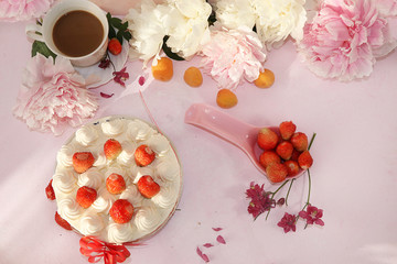 A cup of coffee, strawberry cake and fresh strawberries on a pink background. Summer drinks and delicious strawberry cake, selective focus, top view