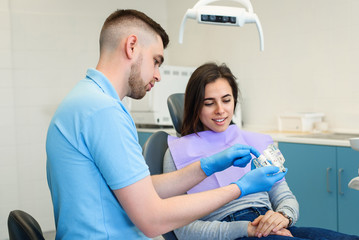 Obraz premium The dentist speaks with the female patient in modern clinic.