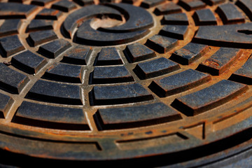 a rusty well cap with a beautiful pattern