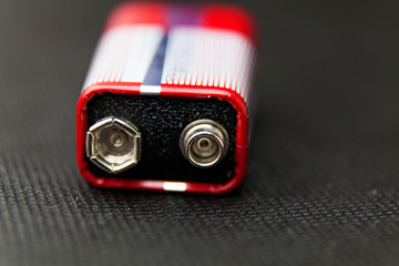 close up of a red and white square battery