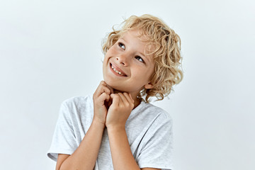 Dreamy,pleased, thinking emotion . Wish concept. Little blonde boy face portrait on white backgound.