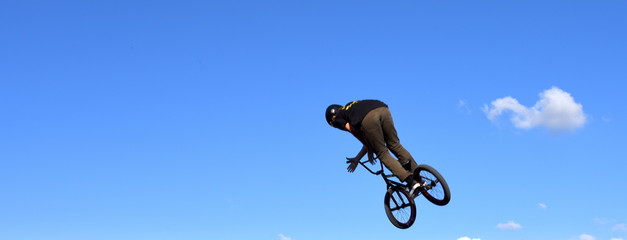Sprung eines BMX-Bikers in den strahlend blauen Himmel