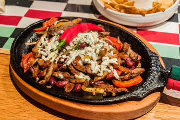 Mexican food - meat stew with vegetables, beans and cheese