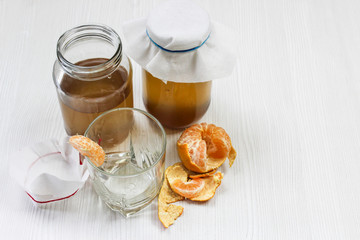 fermented drink, jun tea healthy natural probiotic in a glass jar, with a glass and tangerine ready to drink