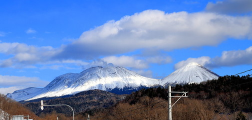 冬の左側が雌阿寒岳、右の円錐形の山は阿寒富士です。
