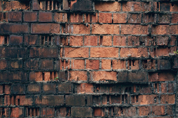 old damaged by bullets and shells brick red wall of the ancient fortification