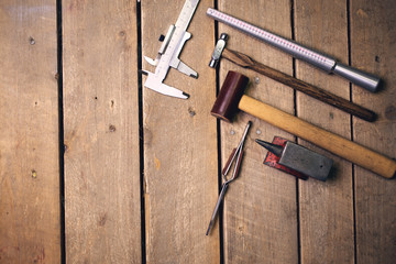 Tools for the repair of jewelry on a wooden table with copy space, top view