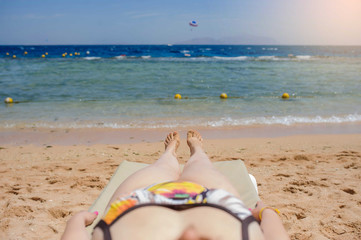 top view of a sexy young woman laying on the lounger on the beach