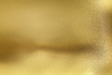 Glowing golden metal wall with scratched surface, abstract texture background