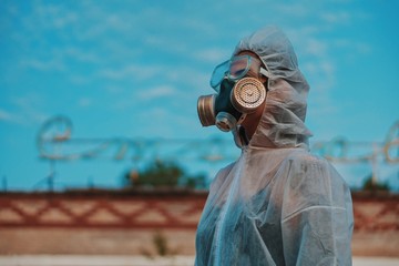 The scientist put on a respirator and a white protective suit against radiation. Close-up profile...