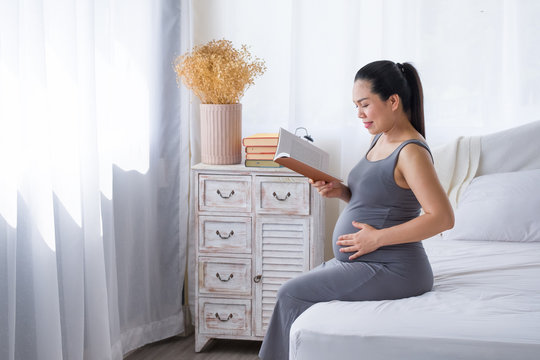 Pregnant woman reading a book for relaxation. - Powered by Adobe