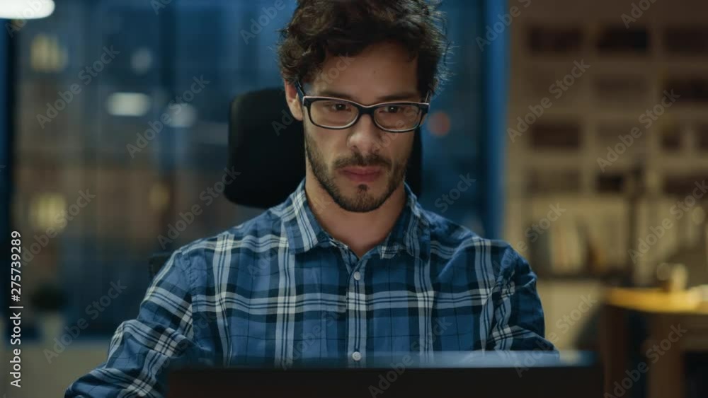 Poster portrait of the handsome and successful young creative entrepreneur working at his desk using laptop