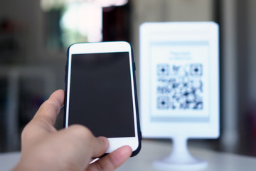 Hands use the phone to scan QR codes to receive discounts on purchases.