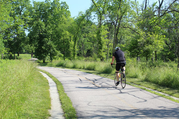 Obraz premium Man riding a bicycle on the North Branch Trail in Morton Grove in summer