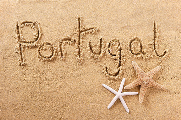 Portugal word written in sand on a sunny summer beach with starfish holiday vacation travel destination sign writing message photo