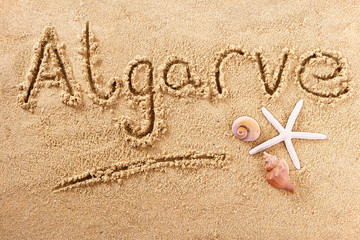 Algarve word written in sand on a sunny portugal summer beach with starfish holiday vacation travel...