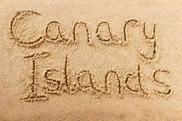 Canary islands word written in sand on a sunny spanish island summer beach holiday vacation travel destination sign writing message photo