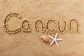 Cancun mexico word written in sand on a sunny mexican summer beach with starfish holiday vacation travel destination sign writing message photo