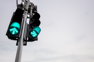 Green traffic light with overcast sky