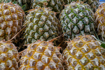 Many fresh pineapples, tropical fruit from Thailand. Select focus.