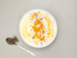 Fresh mango smoothie bowl with coconut, granola and chia. Healthy vegan diet breakfast concept. 