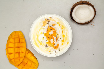 Fresh mango smoothie bowl with coconut, granola and chia. Healthy vegan diet breakfast concept. 