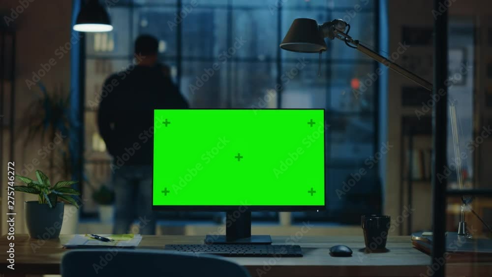 Poster desktop computer with mock-up green screen standing on the wooden desk in the modern creative office